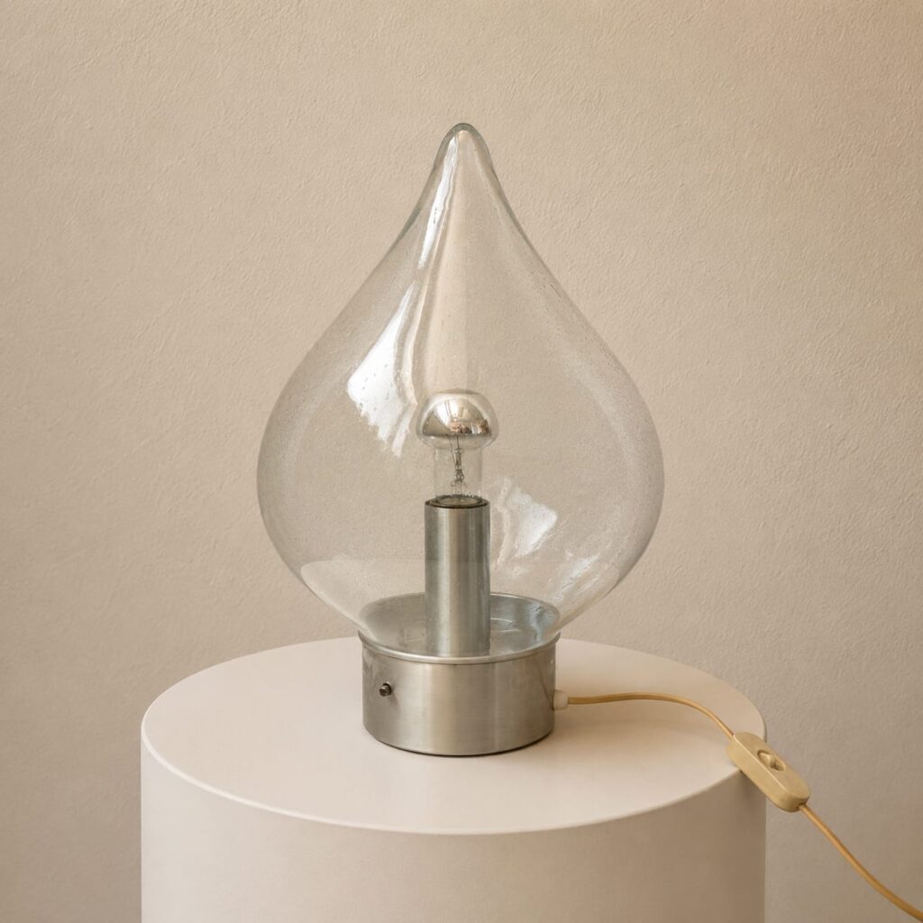 Very rare beautiful table lamp from Alsterfors. A lamp from the 1960s made of an aluminum base and double glass in drop shape. The lamp is in very good condition. The dimensions are: 40 cm height - 26 cm diameter